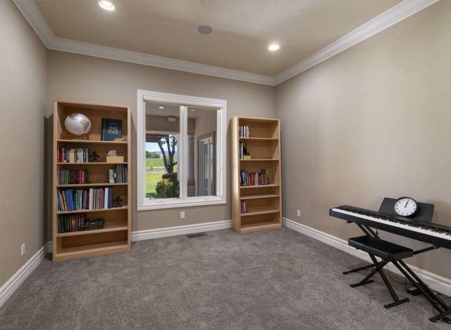 This room offers a perfect blend of relaxation and creativity, featuring two tall bookshelves filled with books and a globe, ideal for a study or library space.