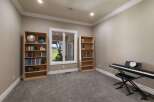 This room offers a perfect blend of relaxation and creativity, featuring two tall bookshelves filled with books and a globe, ideal for a study or library space.