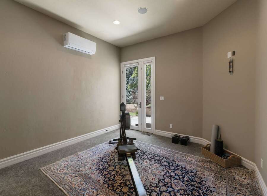 This home gym space features a rowing machine and weights, perfect for your fitness routine.