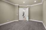 Step into this inviting room, featuring plush grey carpeting and elegant crown molding that adds a touch of sophistication.