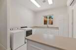 This spacious laundry room features a large island countertop, perfect for folding clothes or additional workspace.