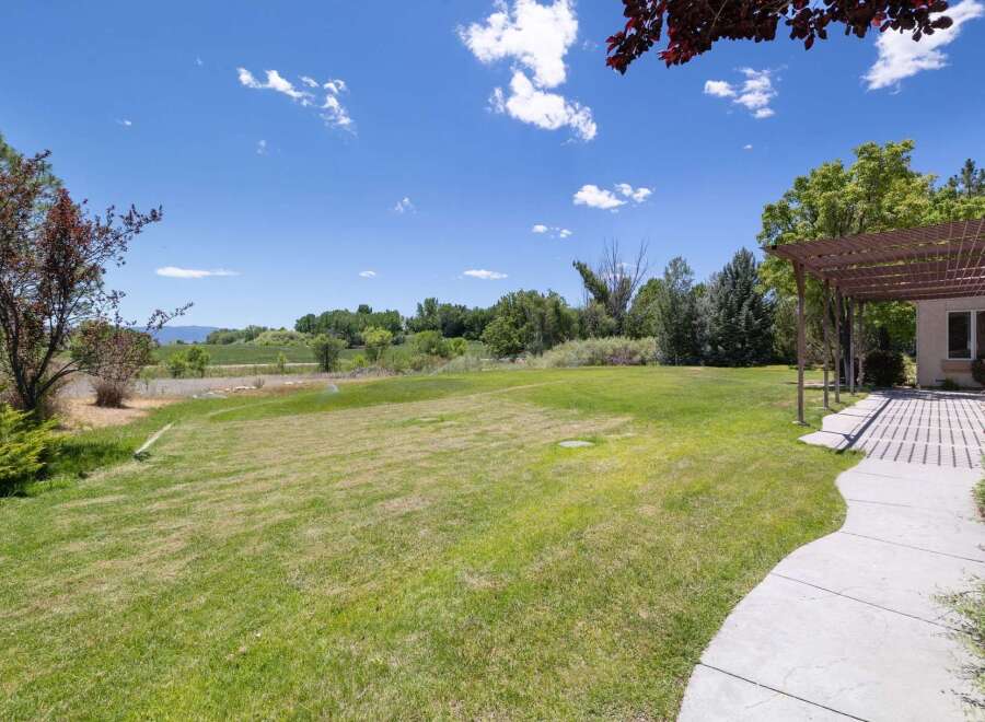 Enjoy the expansive green lawn perfect for outdoor activities and relaxation, complemented by a shaded pergola area ideal for al fresco dining.