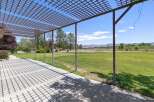 Enjoy the stunning panoramic views from this property's expansive patio, complete with a charming pergola offering dappled shade.
