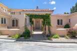 Welcome to this stunning Mediterranean-style home, featuring a grand entrance with a vine-covered archway leading to a beautifully crafted double door.