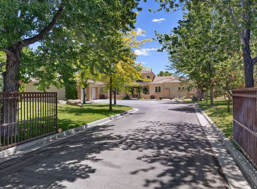 Discover this stunning estate featuring a grand driveway leading to a beautiful home with a tile roof and ample garage space.