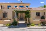 Welcome to this stunning home featuring a charming vine-covered entryway leading to a grand front door.