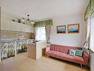 This charming studio apartment features a compact kitchen area with ample cabinet space and a convenient island.