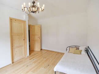 Discover this charming room featuring a comfortable bed adorned with plush pillows and a textured white duvet.