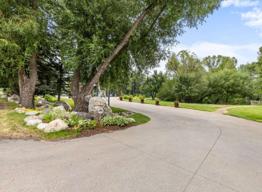 Welcome to this stunning property, marked by the elegant address number 1184, nestled amidst lush greenery and mature trees.