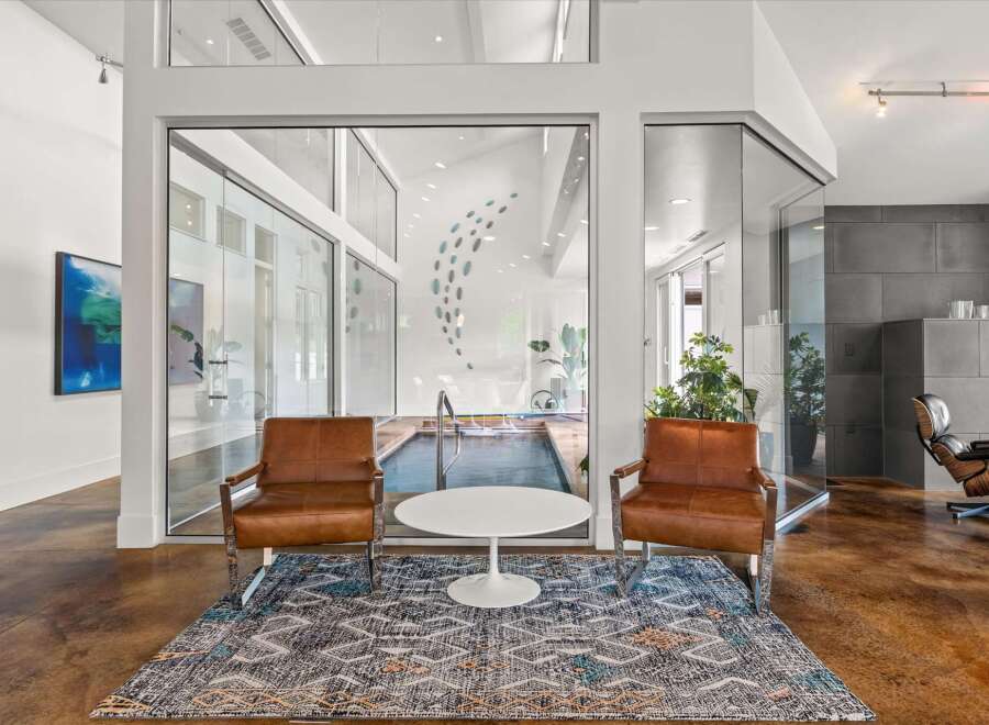 Experience modern luxury in this stunning property featuring a private indoor pool visible through expansive glass walls.