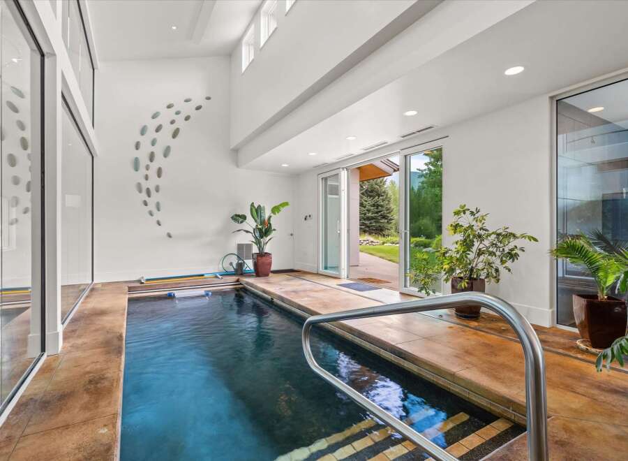 Experience ultimate relaxation in this indoor swimming pool area, featuring a sleek design and ample natural light.