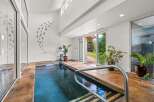 Experience ultimate relaxation in this indoor swimming pool area, featuring a sleek design and ample natural light.