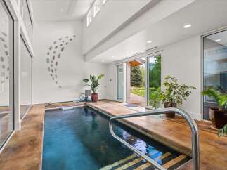 Experience ultimate relaxation in this indoor swimming pool area, featuring a sleek design and ample natural light.