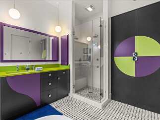 This modern bathroom features a vibrant and playful design, highlighted by a striking purple and lime green vanity with a sleek countertop.