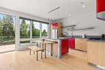 Experience modern living in this stunning kitchen featuring vibrant red cabinetry and sleek stainless steel accents.