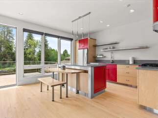 Experience modern living in this stunning kitchen featuring vibrant red cabinetry and sleek stainless steel accents.