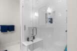 Experience luxury in this modern bathroom featuring a spacious walk-in shower with sleek white subway tile and a built-in bench.