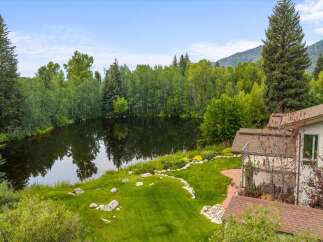 Experience serene living with this stunning property featuring a private pond and lush greenery, perfect for tranquil moments.