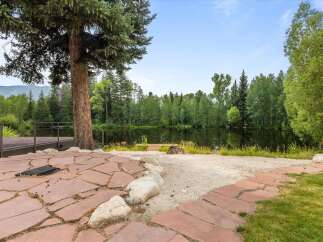 Enjoy serene lakefront living with this stunning property, featuring a spacious stone patio perfect for outdoor entertaining.
