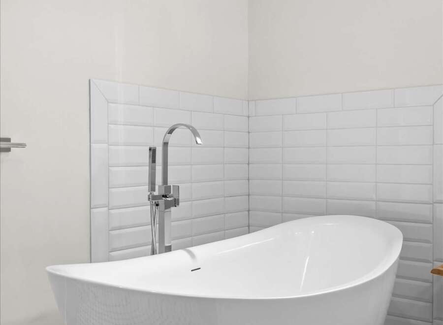 Experience modern luxury in this stunning bathroom, featuring a sleek freestanding bathtub as the centerpiece.