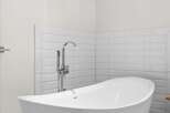Experience modern luxury in this stunning bathroom, featuring a sleek freestanding bathtub as the centerpiece.