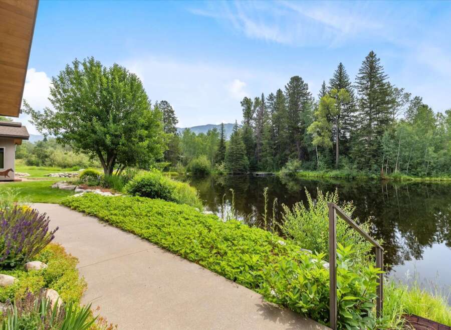 Discover serene living with this stunning property featuring a tranquil pond and lush landscaping.