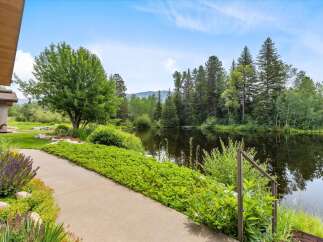 Discover serene living with this stunning property featuring a tranquil pond and lush landscaping.
