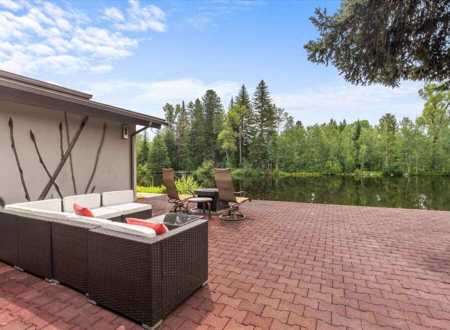 Enjoy serene waterfront living with this stunning property featuring a spacious patio overlooking a tranquil lake.