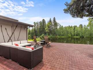 Enjoy serene waterfront living with this stunning property featuring a spacious patio overlooking a tranquil lake.