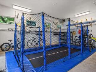 This spacious garage offers a dedicated recreational area with a large trampoline, perfect for family fun and exercise.