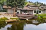 Experience luxurious lakeside living with this stunning property featuring a spacious deck overlooking a tranquil pond.