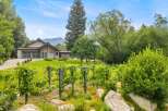 Discover this stunning property featuring a modern home with a spacious garage and a beautiful vineyard in the foreground.