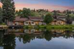 Experience luxury living with this stunning waterfront property, featuring a modern home with expansive windows and a spacious deck overlooking a serene lake.