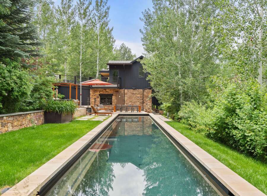 Experience luxury outdoor living with this stunning rectangular swimming pool, perfectly integrated into a lush, green backyard.
