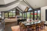 Experience luxurious mountain living in this stunning home featuring a grand dining area with a large wooden table perfect for gatherings.