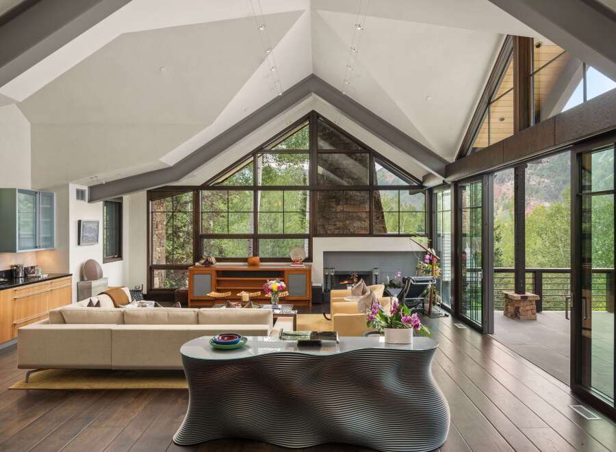 Experience luxurious mountain living in this stunning contemporary home, boasting soaring vaulted ceilings and expansive windows that frame breathtaking forest and mountain views.
