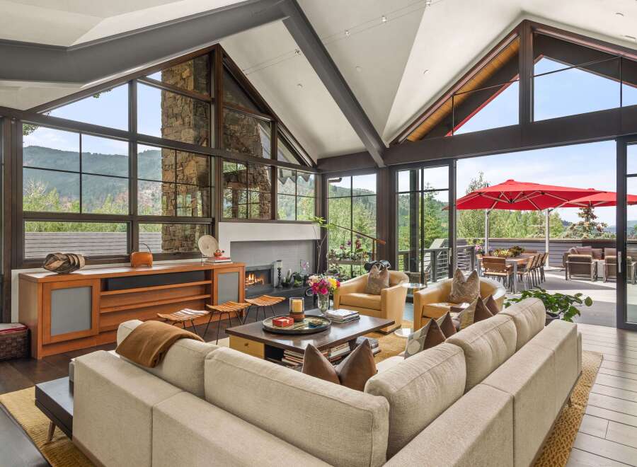 Experience luxury mountain living in this stunning home featuring a grand living area with soaring ceilings and a stone fireplace.