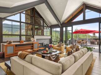 Experience luxury mountain living in this stunning home featuring a grand living area with soaring ceilings and a stone fireplace.