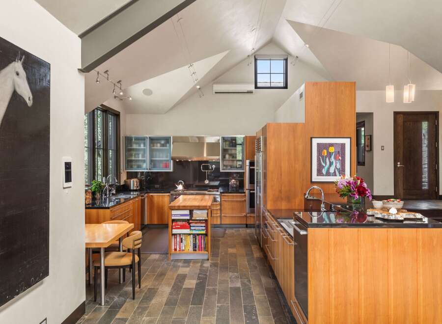 This spacious kitchen boasts modern stainless steel appliances and ample wooden cabinetry, perfect for any culinary enthusiast.
