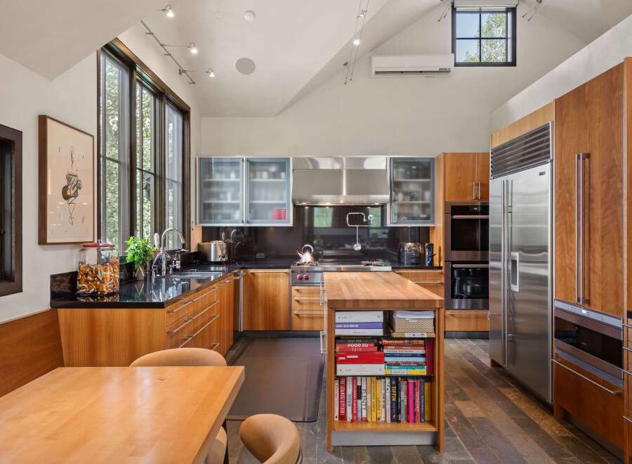 This stunning kitchen boasts custom wood cabinetry and sleek stainless steel appliances, including a Sub-Zero refrigerator and double ovens.