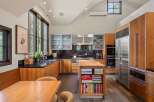 This stunning kitchen boasts custom wood cabinetry and sleek stainless steel appliances, including a Sub-Zero refrigerator and double ovens.