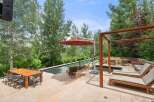 Experience luxury outdoor living with this stunning patio featuring a sleek infinity pool and a cozy fire pit area.