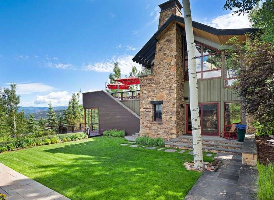 Experience luxury mountain living in this stunning home featuring a grand stone fireplace and expansive windows that capture breathtaking panoramic views.