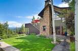Experience luxury mountain living in this stunning home featuring a grand stone fireplace and expansive windows that capture breathtaking panoramic views.