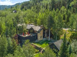 Experience luxury mountain living in this stunning contemporary home nestled amidst lush greenery.