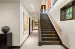 Experience luxury living in this stunning home featuring a grand staircase and a beautifully appointed hallway.