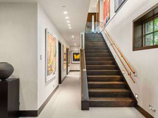 Experience luxury living in this stunning home featuring a grand staircase and a beautifully appointed hallway.