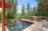 Experience luxury outdoor living with this stunning patio featuring a modern hot tub and a sleek gas fireplace.