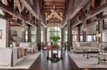 Experience rustic luxury in this grand living space, featuring soaring exposed wooden beams and a magnificent chandelier.