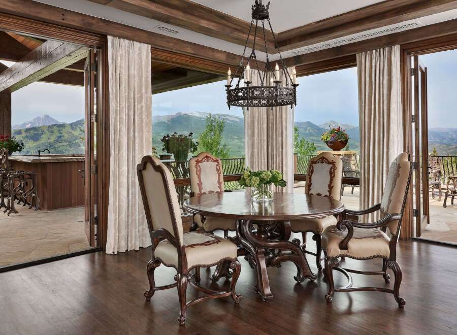Experience luxurious mountain living in this exquisite dining room, featuring a grand wooden table and chairs perfect for intimate gatherings.